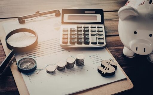 Calculator, coins, piggy bank, and financial report illustrating key personal finance and investment lessons.